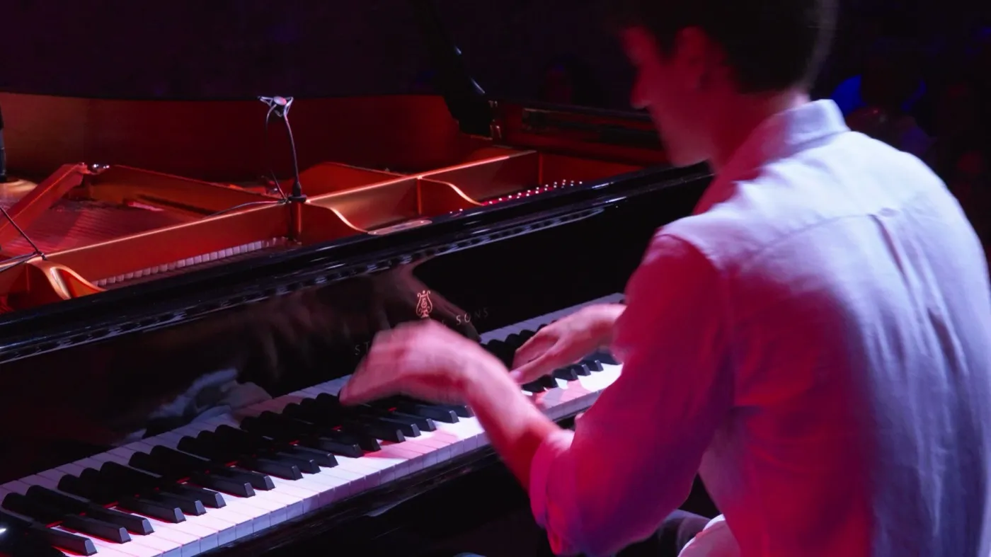 Pablo toca bajo luz roja en concierto