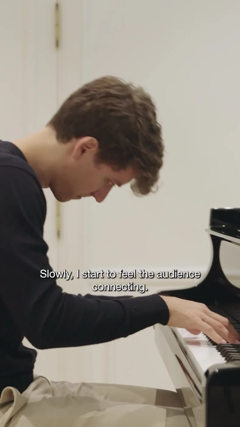 Pablo al piano en una sala blanca, con subtítulos