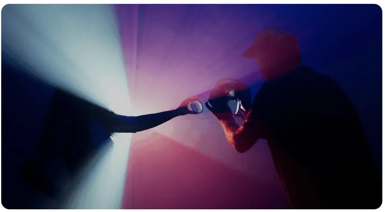 A hand held up to a beam of light on a dark set